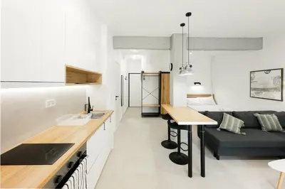 a kitchen and living room with a couch and a table at Studio Garden next to Metro station in Piraeus