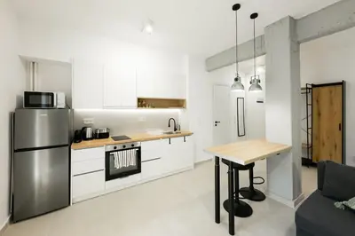 a kitchen with a stainless steel refrigerator and a table at Studio Garden next to Metro station in Piraeus