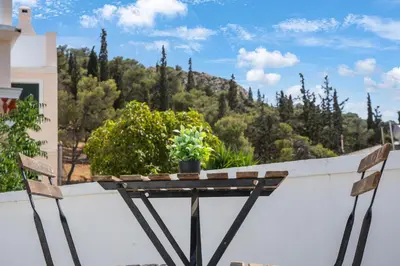 a balcony with two chairs and a table with a plant at Athens Apartment on Lycabettus Hill with Rooftop View Access in Athens