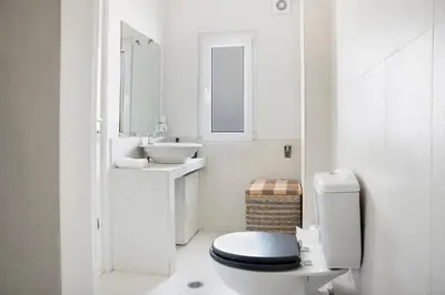 a white bathroom with a toilet and a sink at Athens Apartment on Lycabettus Hill with Rooftop View Access in Athens