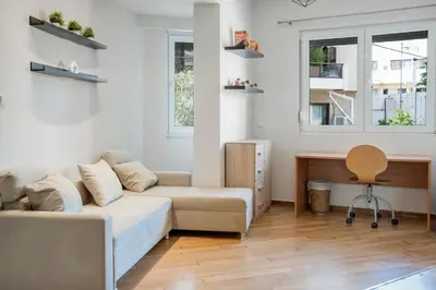 a living room with a couch and a desk at Athens Apartment on Lycabettus Hill with Rooftop View Access in Athens