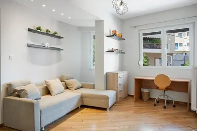 a living room with a couch and a desk at Athens Apartment on Lycabettus Hill with Rooftop View Access in Athens