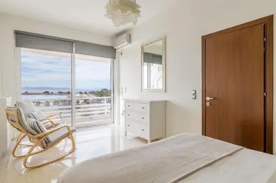 a bedroom with a bed and a chair and a window at 3 Bedroom Apartment in Glyfada in Athens