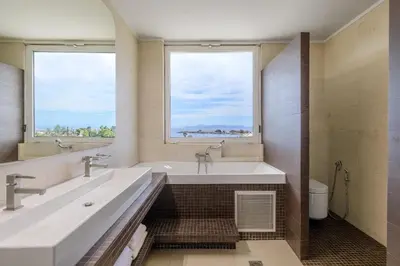 a bathroom with two sinks and a tub with two windows at 3 Bedroom Apartment in Glyfada in Athens