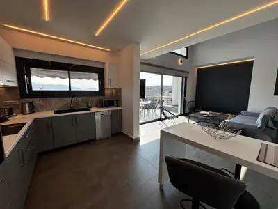 a kitchen with a table and a living room at The Artist House - Best Sea View in Porto Rafti in Porto Rafti