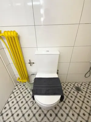 a bathroom with a white toilet with a black seat at Kipseli Comfort Apartment in Athens