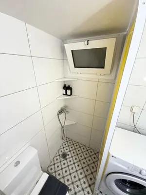 a small bathroom with a toilet and a tv at Kipseli Comfort Apartment in Athens