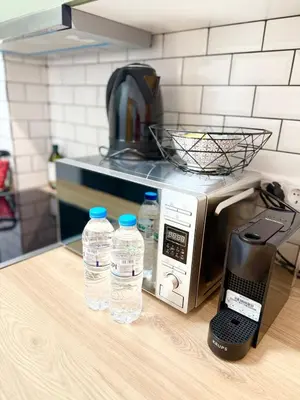 a counter with two bottles of water next to a microwave at Kipseli Comfort Apartment in Athens