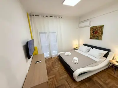 a bedroom with a large bed and a television at Kipseli Comfort Apartment in Athens