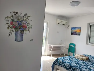 a bedroom with a vase of flowers on the wall at Helen's holiday home in Athens