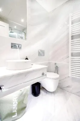 a white bathroom with a sink and a toilet at Comfort studio in Kolonaki 2 in Athens