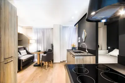 a kitchen with a sink and a living room at Comfort studio in Kolonaki 2 in Athens