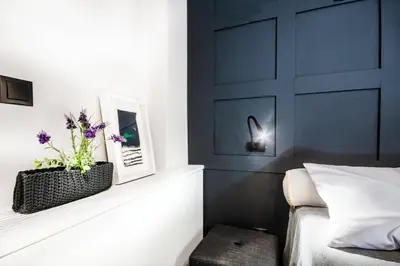 a bedroom with a black headboard and a white bed at Comfort studio in Kolonaki 2 in Athens