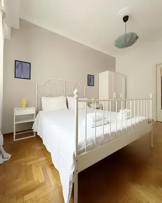 a bedroom with a white bed with a white bed frame at Acropolis Nest in Athens