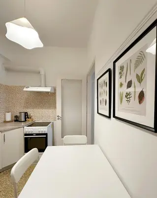a white kitchen with a white table and chairs at Acropolis Nest in Athens