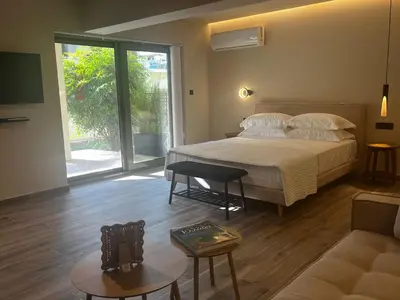 a bedroom with a bed and a living room at Χenion Inn - Athens Airport, Easy Check In Anytime in Markopoulo
