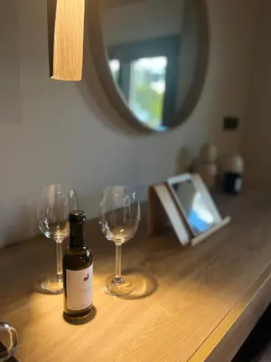 a bottle of wine and two wine glasses on a table at Χenion Inn - Athens Airport, Easy Check In Anytime in Markopoulo