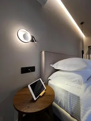 a bedroom with a bed and a table with a laptop on it at Χenion Inn - Athens Airport, Easy Check In Anytime in Markopoulo