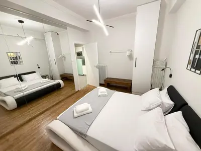 a bedroom with a large bed and a mirror at Gyzi Comfort Apartment in Athens