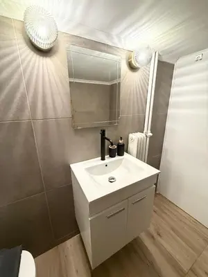 a bathroom with a white sink and a mirror at Gyzi Comfort Apartment in Athens