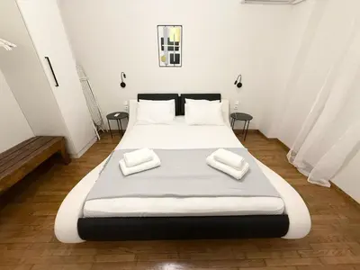a bedroom with a large bed with two towels on it at Gyzi Comfort Apartment in Athens