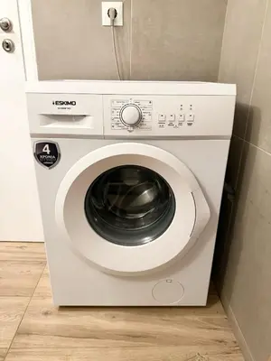 a white washing machine sitting in a room at Gyzi Comfort Apartment in Athens