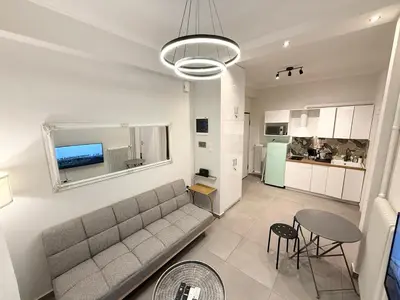 a living room with a couch and a table and a kitchen at Gyzi Comfort Apartment in Athens