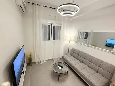 a living room with a couch and a flat screen tv at Gyzi Comfort Apartment in Athens