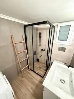 a bathroom with a shower with a cross on the wall at Gyzi Comfort Apartment in Athens