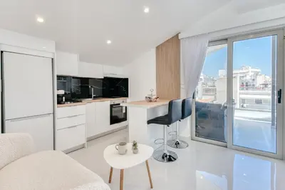 a kitchen with white cabinets and a table and chairs at Ayla Studio Athens in Athens