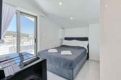 a bedroom with a bed and a large window at Ayla Studio Athens in Athens