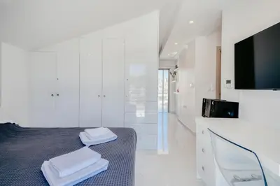 a white room with a bed and a tv at Ayla Studio Athens in Athens