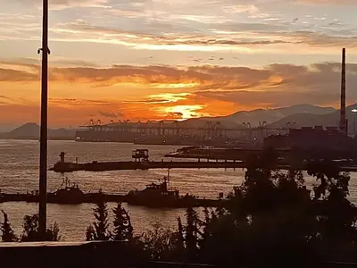 a sunset over a harbor with boats in the water at 