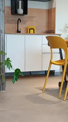 a kitchen with a yellow chair and a white cabinet at 