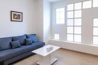 a living room with a blue couch and a white table at Urban Athens - Studio #1 in Athens