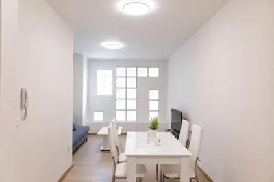a white dining room with a white table and chairs at Urban Athens - Studio #1 in Athens