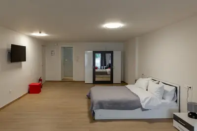 a bedroom with a white bed and a television at Urban Athens - Studio #4 in Athens
