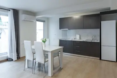 a kitchen with a white table and white chairs at Urban Athens - Studio #4 in Athens