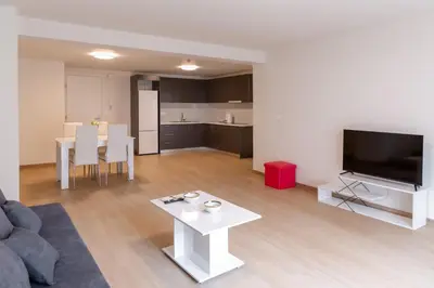 a living room with a couch and a tv and a table at Urban Athens - One Bedroom in Athens