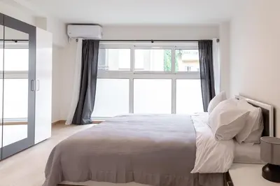 a bedroom with a bed and a large window at Urban Athens - One Bedroom in Athens