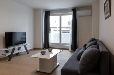 a living room with a couch and a television at Urban Athens - One Bedroom in Athens