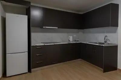 a kitchen with black cabinets and a white refrigerator at Urban Athens - One Bedroom in Athens