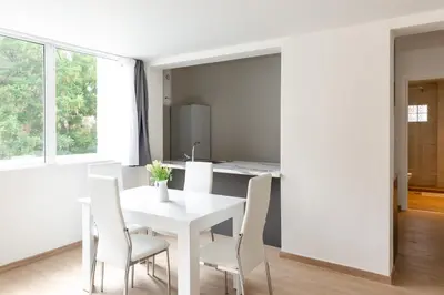 a white dining room with a white table and chairs at Urban Athens - Two Bedroom #7 in Athens