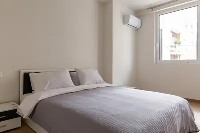 a white bedroom with a bed and a window at Urban Athens - Two Bedroom #7 in Athens