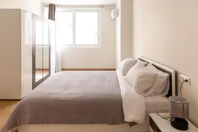 a bedroom with a bed with white sheets and a window at Urban Athens - One Bedroom #8 in Athens