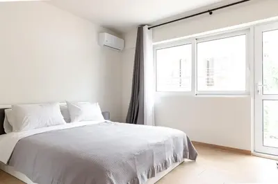 a white bedroom with a bed and a window at Urban Athens - Two Bedroom #9 in Athens