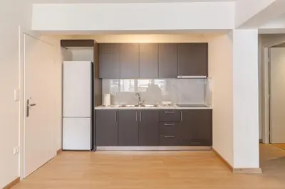 a kitchen with black cabinets and a white refrigerator at Urban Athens - Two Bedroom #9 in Athens