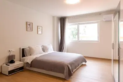 a white bedroom with a bed and a window at Urban Athens - Studio #10 in Athens