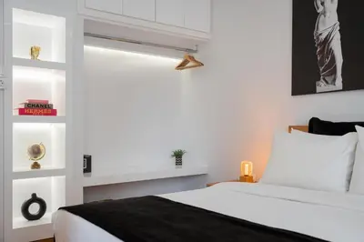a bedroom with a white bed and a window at Nostos Athens Luxury Residence in Athens
