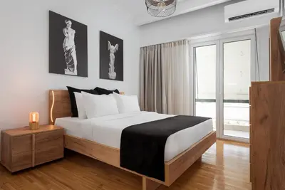 a bedroom with a large bed and a window at Nostos Athens Luxury Residence in Athens